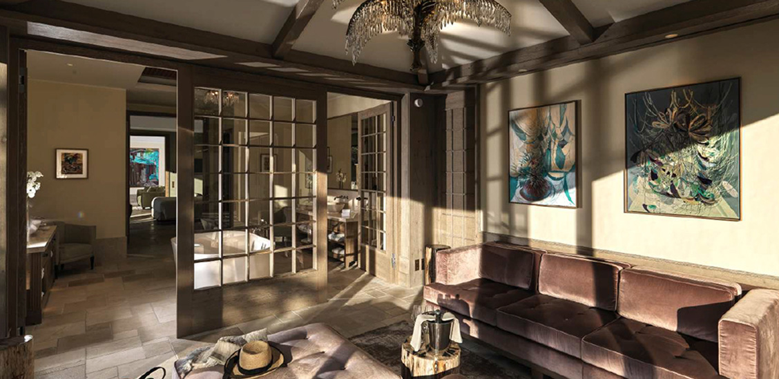 Elegantes Wohnzimmer in La Coquillade mit Kunstwerken, einem bequemen Sofa und viel natürlichem Licht.