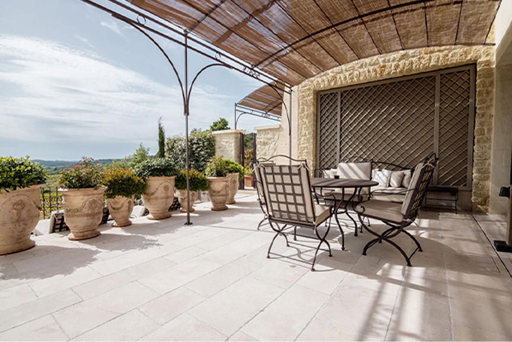 Gemütliche Terrasse mit Pflanzen, einem Tisch und Stühlen, umgeben von einer malerischen Landschaft in La Coquillade.