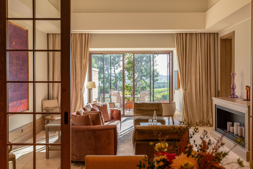 Helles Wohnzimmer mit Blick auf die Terrasse und Weinberge, stilvoll eingerichtet mit modernen Möbeln und Kunstwerken.
