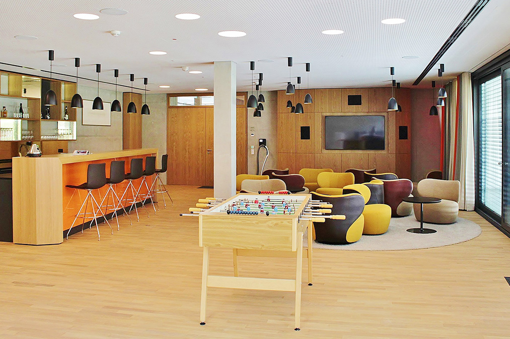 Moderne Lounge mit Bar, Tischfußball und gemütlichen Sitzbereichen für entspannte Treffen bei Storz & Bickel.