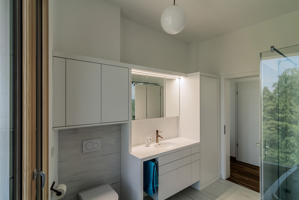 Modernes Badezimmer mit hellem Design, Spiegel, Waschbecken und Dusche in einem Privathaus in Süddeutschland.